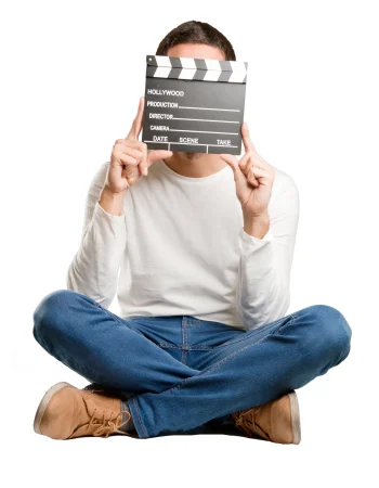 seated-happy-young-man-using-clapperboard seated-happy-young-man-using-clapperboard